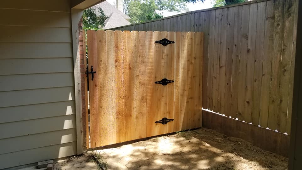 Custom wood gate with decorative black iron strap hinges