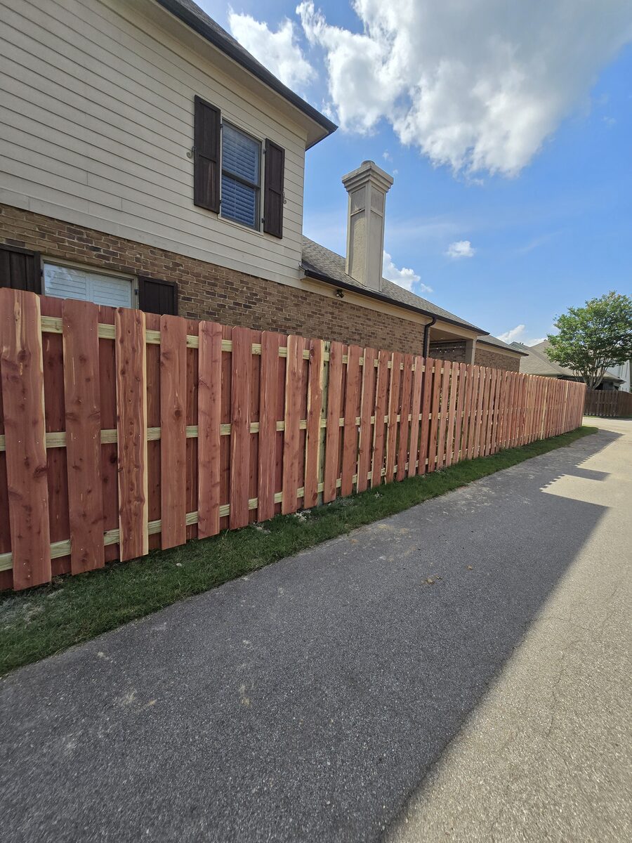 Red cedar shadowbox fence along brick home