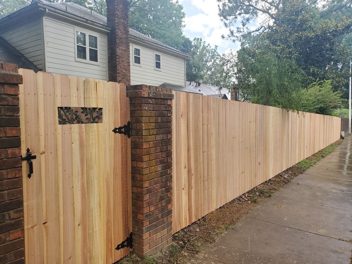 Western cedar fence with brick columns and iron-insert gate