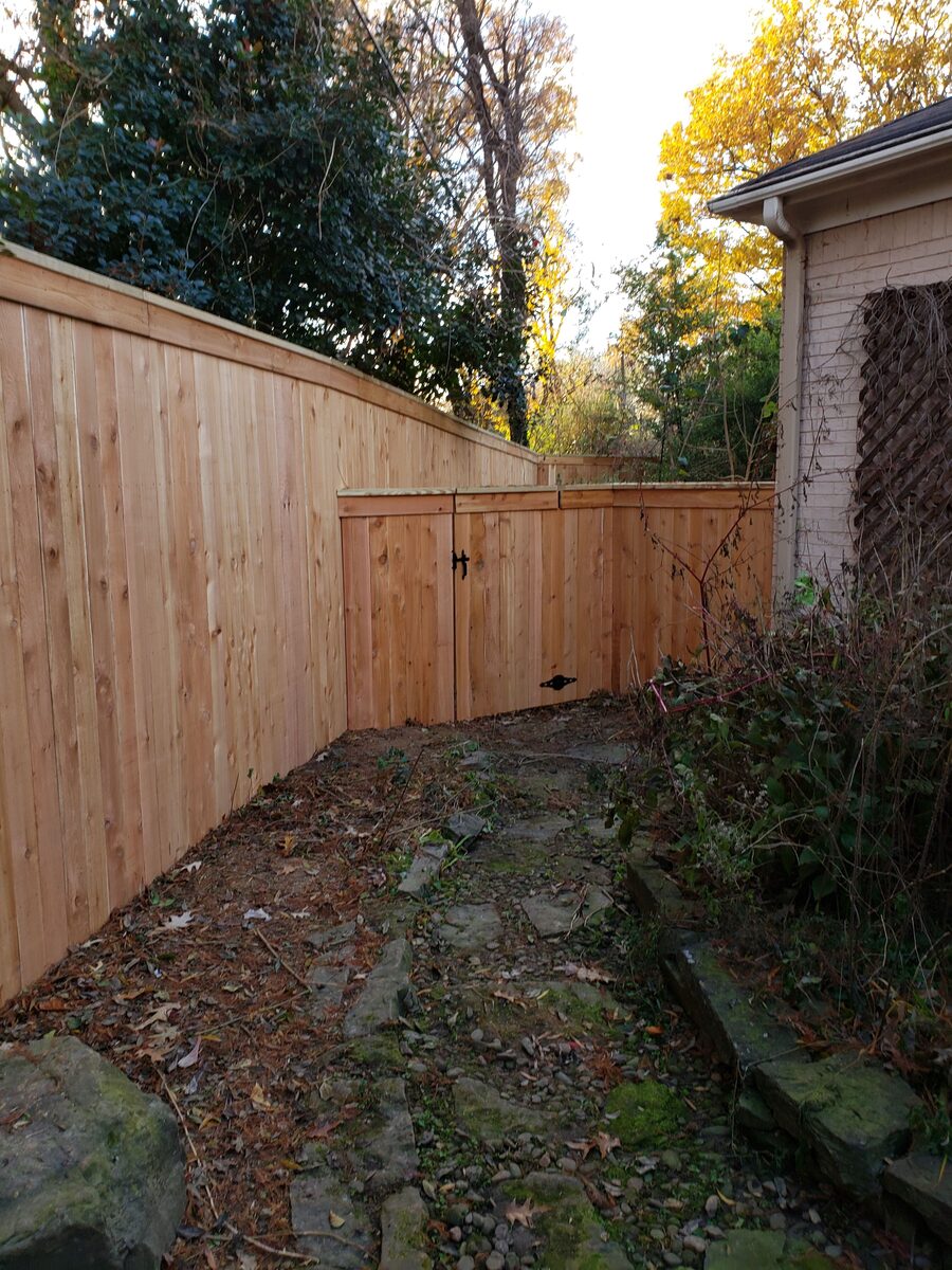 Cap-rail western cedar fence with double gate and stone path