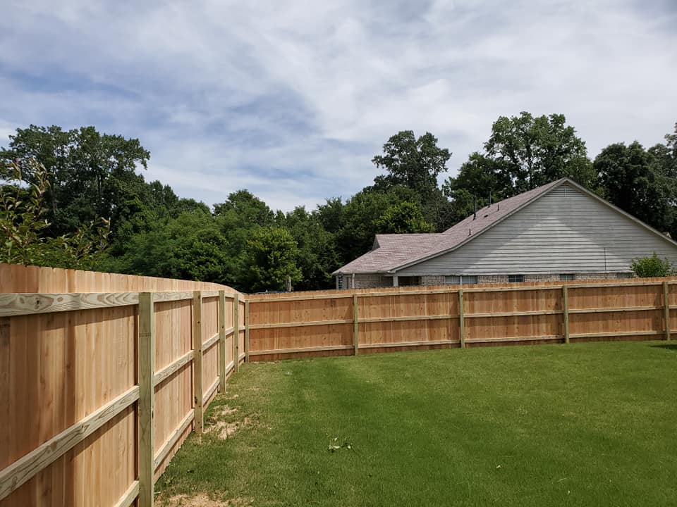 Long run of wood privacy fence enclosing large backyard